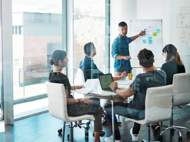 A corporate team in a working session in a glass meeting room